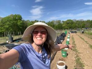 Nancy Dru pointing to all the tomato planting holes.
