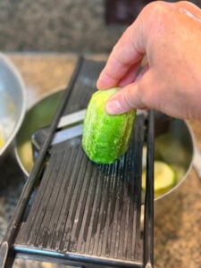 Using the mandolin to slice the cucumbers for canning.