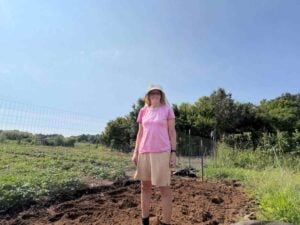 Nancy standing in the tilled bed
